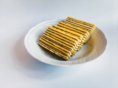 Lapis Kek veya Lapis Okunaklı. beyaz arka plan üzerinde izole beyaz plaka üzerinde geleneksel endonezya tatlı katmanlı kek. 