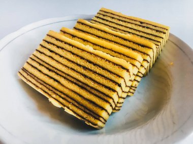 Lapis Kek veya Lapis Okunaklı. beyaz arka plan üzerinde izole beyaz plaka üzerinde geleneksel endonezya tatlı katmanlı kek. 