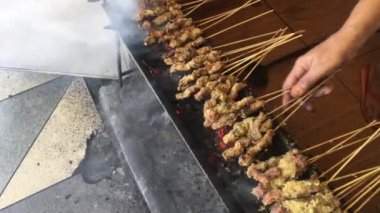Kelapa sate veya klopo veya hindistan cevizi satay, tavuk veya et insanlar tarafından kırmızı ateş ızgara üzerinde hindistan cevizi madde ile satay satay. surabaya geleneksel satay, Doğu Java, Endonezya ile beyaz plaka üzerinde