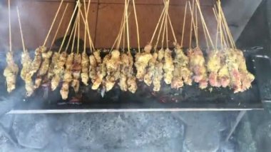 Kelapa sate veya klopo veya hindistan cevizi satay, tavuk veya et insanlar tarafından kırmızı ateş ızgara üzerinde hindistan cevizi madde ile satay satay. surabaya geleneksel satay, Doğu Java, Endonezya ile beyaz plaka üzerinde