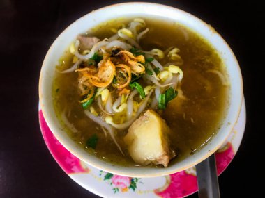 Soto Sapi Boyolali. Boyolali dan Beef Soto, Beyaz kase ve siyah ahşap masa arka plan Boyolali Endonezya Geleneksel Gıda