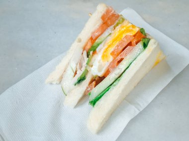 Jambonlu sandviç, yumurta, domates, marul ve beyaz ekmek. Beyaz arka planda yalıtılmış yukarıda görünüm