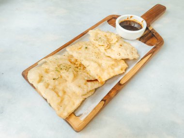 Tempe Mendoan ince tempehten yapılmış, un ile kızartılmış, tadı lezzetli ve soya soslu, beyaz arka planda izole edilmiş soya soslu bir tür tempeh tabağıdır.