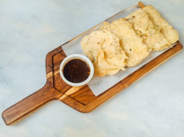 Tempe Mendoan ince tempehten yapılmış, un ile kızartılmış, tadı lezzetli ve soya soslu, beyaz arka planda izole edilmiş soya soslu bir tür tempeh tabağıdır.