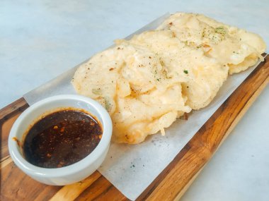 Tempe Mendoan ince tempehten yapılmış, un ile kızartılmış, tadı lezzetli ve soya soslu, beyaz arka planda izole edilmiş soya soslu bir tür tempeh tabağıdır.