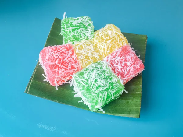 Cenil Cake with grated coconut and sugar on banana leaf isolated on blue background. Cenil is traditional cake from Java, Indonesia. Made from starch