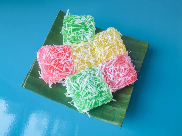 Cenil Cake with grated coconut and sugar on banana leaf isolated on blue background. Cenil is traditional cake from Java, Indonesia. Made from starch