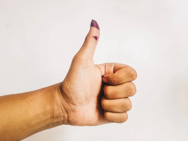woman's thumb up in purple ink isolated on a white background. Purple ink spots from the voters' fingers gave evidence of Indonesian elections