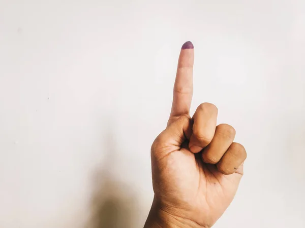 One finger or index finger of hands of a woman who is isolated on a white background. Purple ink spots from the voters\' fingers gave evidence of Indonesian elections. Sign for Jokowi supporter