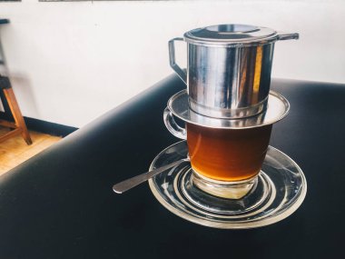 koyu arka planda metal su ısıtıcısı ve cam ile kahve yapma