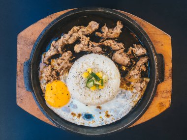 Güneşli kızarmış yumurta ve Izgara Et veya garnitür mısır ve pırasa yakın çekim siyah arka plan üzerinde izole sıcak tabak ile sığır eti ile Pirinç