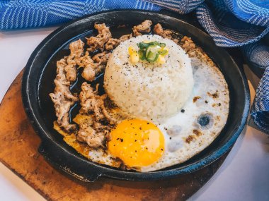 Güneşli kızarmış yumurta ve Izgara Et veya garnitür mısır ve pırasa yakın çekim siyah arka plan üzerinde izole sıcak tabak ile sığır eti ile Pirinç