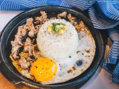 Pilav Güneşli kızarmış yumurta ve Izgara Et veya garnitür mısır ve pırasa yakın çekim ahşap masada sıcak tabakta sığır eti