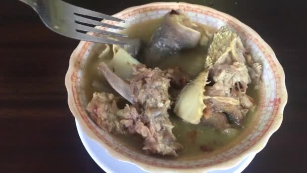 腾克伦用汤煮的羊肉 用肋骨和骨头煮熟 印尼传统食品由烧烤羔羊的骨头分离在黑木背景 — 图库视频影像
