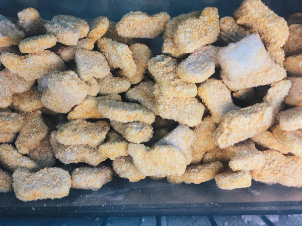 süpermarkette bir soğutucu da çiğ dondurulmuş tavuk nuggets yığını