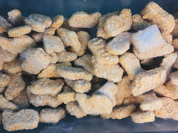 süpermarkette bir soğutucu da çiğ dondurulmuş tavuk nuggets yığını