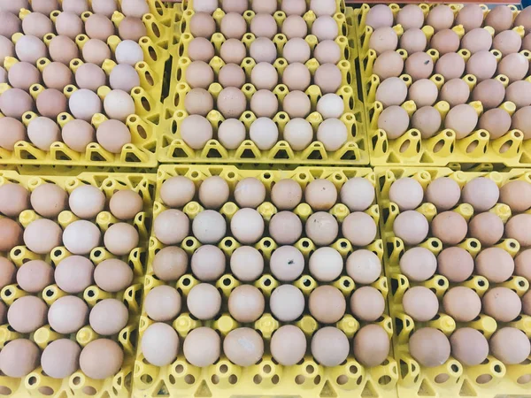 Brown or raw chicken eggs in the yellow egg tray cardboard, fresh raw chicken eggs in package for sale in supermarket