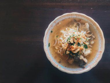 Soto Sapi Boyolali. Boyolali dan Beef Soto, Beyaz kase ve siyah ahşap masa arka plan Boyolali Endonezya Geleneksel Gıda