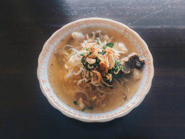 Soto Sapi Boyolali. Boyolali dan Beef Soto, Beyaz kase ve siyah ahşap masa arka plan Boyolali Endonezya Geleneksel Gıda