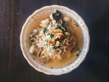 Soto Sapi Boyolali. Boyolali dan Beef Soto, Beyaz kase ve siyah ahşap masa arka plan Boyolali Endonezya Geleneksel Gıda