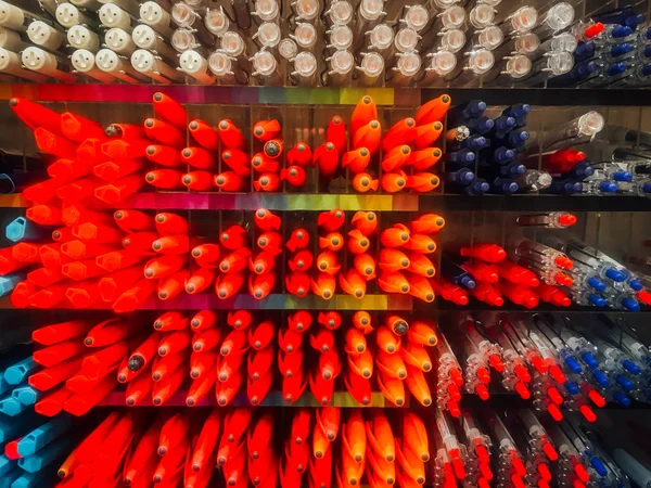 Colored pens on shelves In the shop, office supplies and stationery. Colorful pens arranged on shelves selling stationery