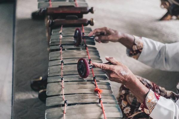 Bir adam gamelan Cinsiyet veya Slenthem oynarken batik ve blankon kullanın. Gamelan, Bali ve Java, Endonezya'da geleneksel vurmalı çalgılar
