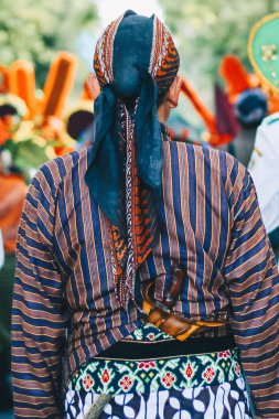 Yogyakarta karnavalda Cava kültürünün zenginliğini göstermek için keris, batik ve blangkon ile geleneksel Cava kıyafetleri giyen adam