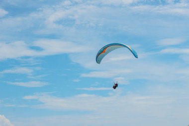 Spor, mavi gökyüzünde kanat uçan yamaçparaşütü