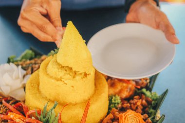 el kutlama için bıçak ile Nasi Tumpeng Nusantara kesti. Ülkede çeşitli bölgesel mutfaklardan yan yemekleri ile sarı pirinç ayrıntılı Endonezya rijsttafel