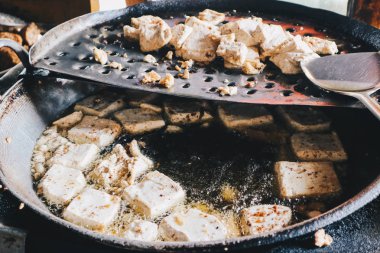 Beyaz tofu küpleri kızartılmış veya yağ ile büyük bir tavada pişmiş olmak