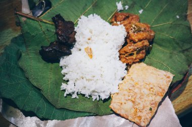 Nasi Jamblang veya Sego Jamblang. Cirebon, Batı Java, Endonezya geleneksel pirinç yemeği. Kokulu tik yaprağına sarılmış ve bol camı ile servis edilen buğulanmış pirinç