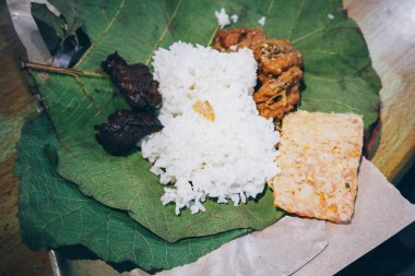 Nasi Jamblang veya Sego Jamblang. Cirebon, Batı Java, Endonezya geleneksel pirinç yemeği. Kokulu tik yaprağına sarılmış ve bol camı ile servis edilen buğulanmış pirinç