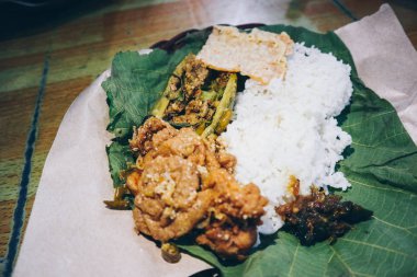 Nasi Jamblang veya Sego Jamblang. Cirebon, Batı Java, Endonezya geleneksel pirinç yemeği. Kokulu tik yaprağına sarılmış ve bol camı ile servis edilen buğulanmış pirinç