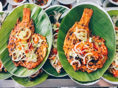 Asya tarzında deniz ürünleri ile kızarmış pilav palmiye yaprakları ile tabaklarda servis.