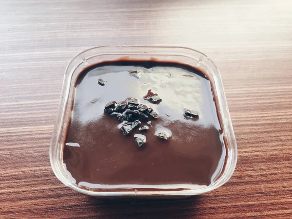 木製テーブルのプラスチック容器に入ったチョコレートアイスクリーム — ストック写真