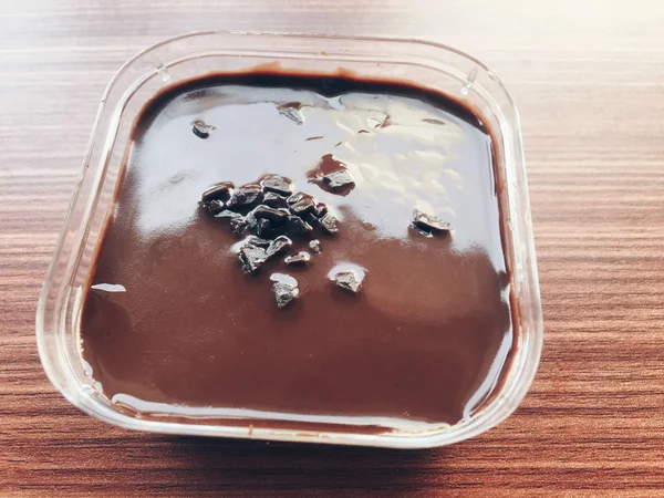 木製テーブルのプラスチック容器に入ったチョコレートアイスクリーム — ストック写真