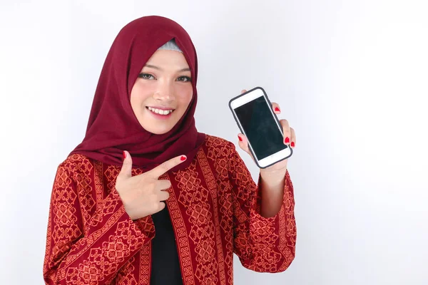 Молода Жінка Азіатського Ісламу Посміхається Вказуючи Смартфон Стоїть Білому Фоні — стокове фото