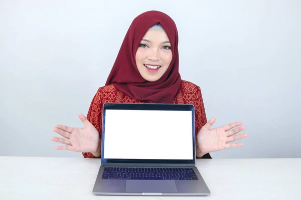 年轻的亚洲伊斯兰女性微笑着指指点点 在笔记本电脑的白色空白屏幕上对着摄像机 — 图库照片