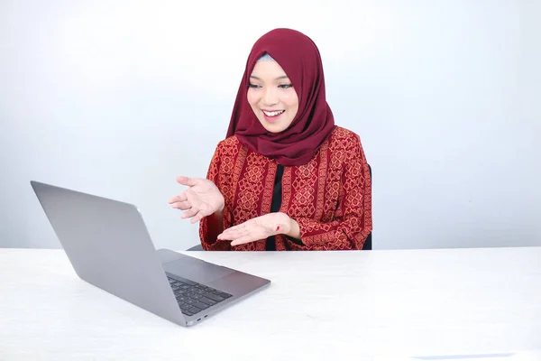 在白色背景的笔记本电脑上工作时 年轻的亚洲伊斯兰女性微笑着指手画脚 — 图库照片