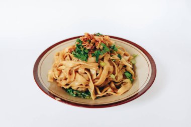 Kızarmış erişte ve koyu soya soslu domuz eti. Endonezya, Bakmie Jowo veya Fried Kwetiau 'nun beyaz arka planda soyutlandığını söyledi