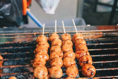Izgara fırında ızgara Köfte Satay pişiriyorum. Bu geleneksel Endonezya sokak yemekleri köfteden yapılır..