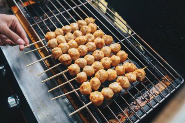 Izgara fırında ızgara Köfte Satay pişiriyorum. Bu geleneksel Endonezya sokak yemekleri köfteden yapılır..