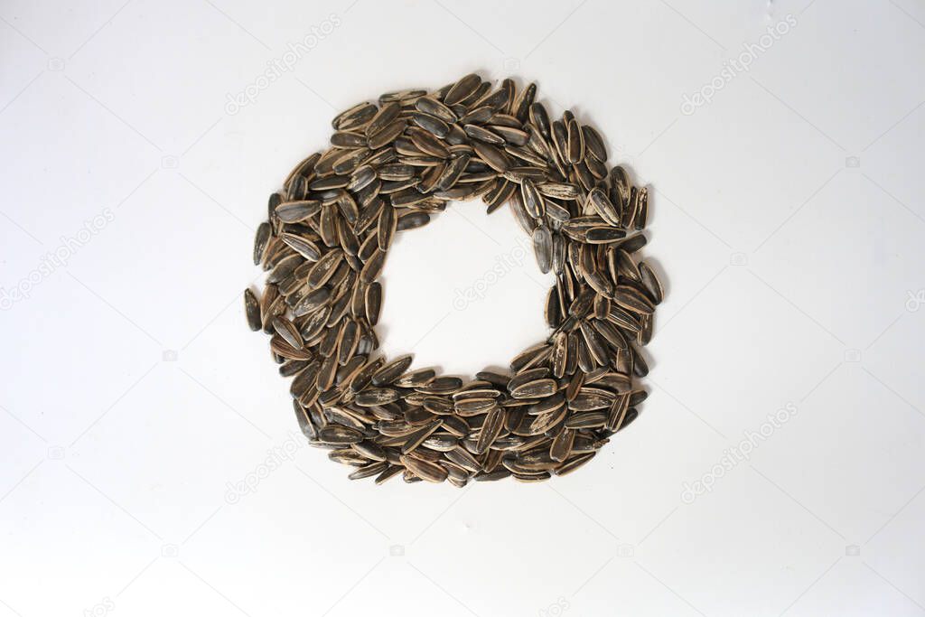 Pile of fried sunflower seeds with circle shape isolated on white background.