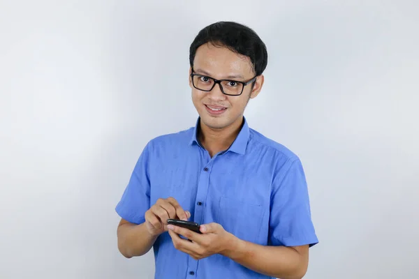 带着手机的年轻亚洲人的笑脸和笑脸 蓝色衬衫广告模型概念 — 图库照片