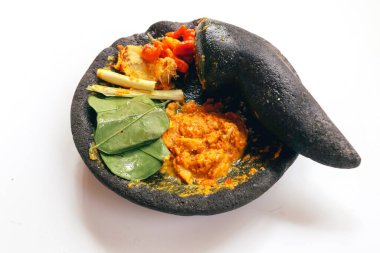 Asya 'dan geleneksel taş havan topuzu ve baharatlı biber, sarı baharat çeşnisi, yaprak, beyaz arka planda bulunan Endonezya' dan sızan yaprak.