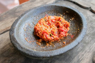 Taş havan (cobek) üzerinde taze sambal servis edilir. Sambal, Endonezya 'dan geleneksel bir sostur..
