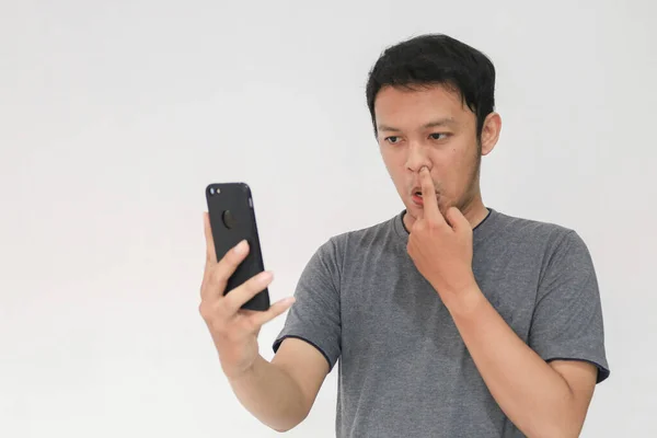 Ung Asiatisk Man Tittar Smartphone Med Näsa Plockning Gest — Stockfoto