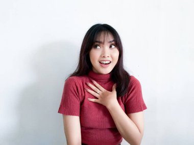 Göğsüne dokunan güzel Asyalı kızın şok olmuş yüzü kırmızı gömlek giyiyor. Reklam modeli konsepti.
