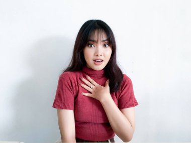 Göğsüne dokunan güzel Asyalı kızın şok olmuş yüzü kırmızı gömlek giyiyor. Reklam modeli konsepti.