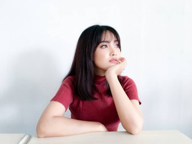 Asyalı güzel kız dışarı bakar ya da çenesini tutarak hayal kurar.